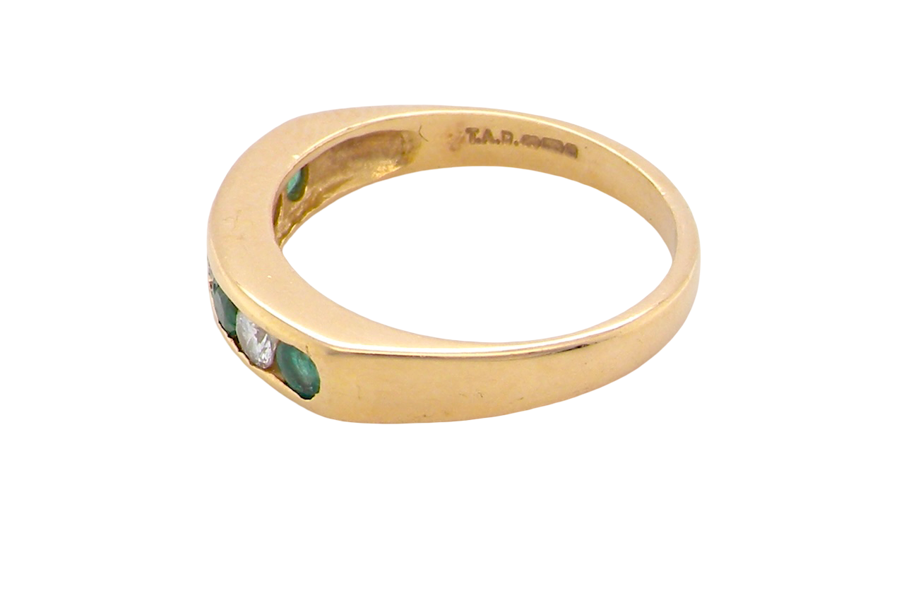 side An 18 carat yellow gold half hoop eternity ring. Set with four round emeralds, each 3mm, and alternate set with brilliant cut white diamonds, each 3mm (total est 0.30 carats)