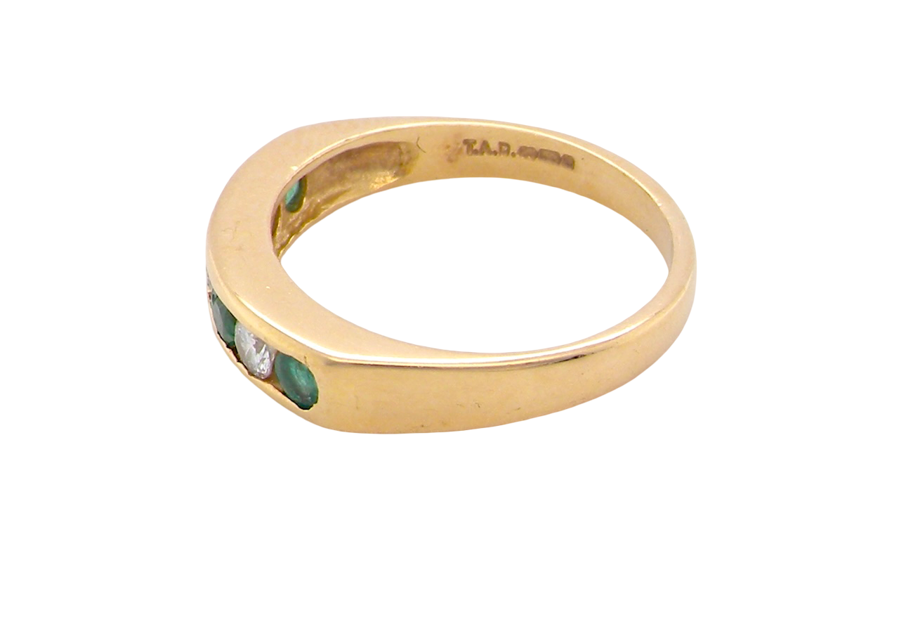 side An 18 carat yellow gold half hoop eternity ring. Set with four round emeralds, each 3mm, and alternate set with brilliant cut white diamonds, each 3mm (total est 0.30 carats)