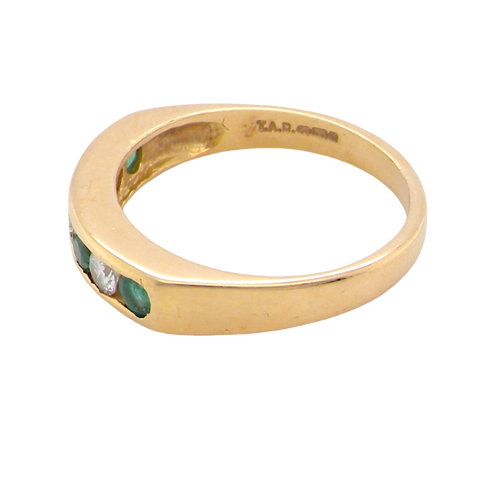 side An 18 carat yellow gold half hoop eternity ring. Set with four round emeralds, each 3mm, and alternate set with brilliant cut white diamonds, each 3mm (total est 0.30 carats)