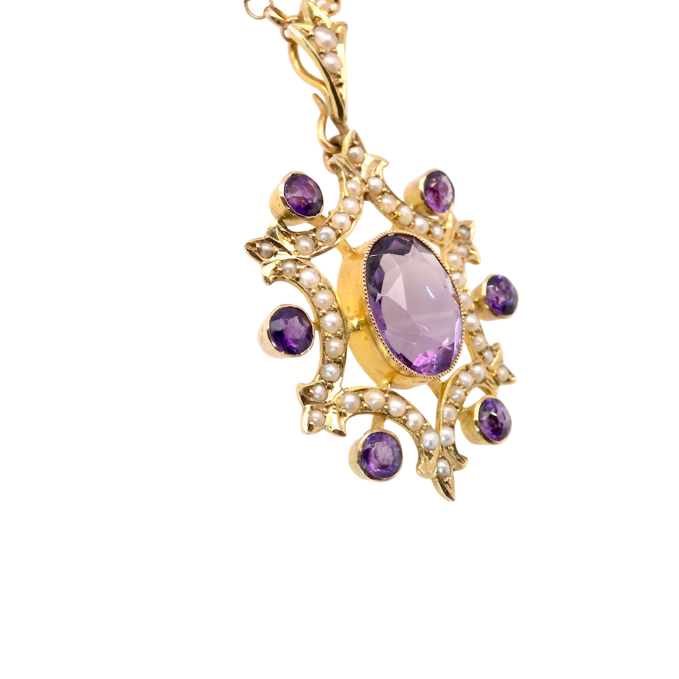 Gold pendant with purple gemstones on a white background