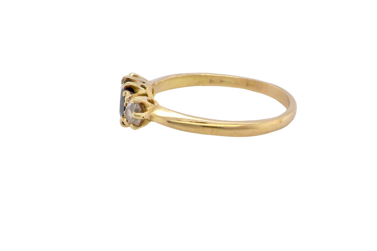 side An early 20th-century trilogy ring set with a mid to dark cornflower blue central sapphire,