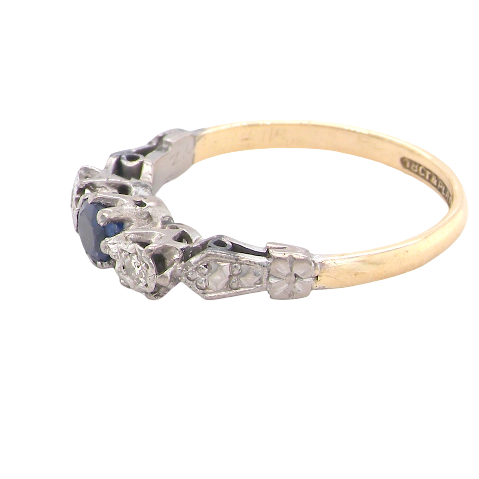 side An early 20th century engagement ring. The centre stone a dark blue sapphire