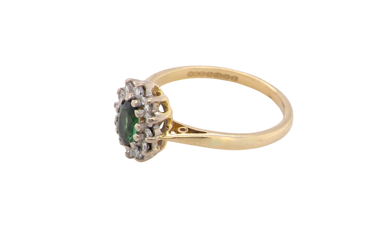 side An elegant 18 carat gold cluster ring featuring a beautifully proportioned 6 × 4mm green tourmaline