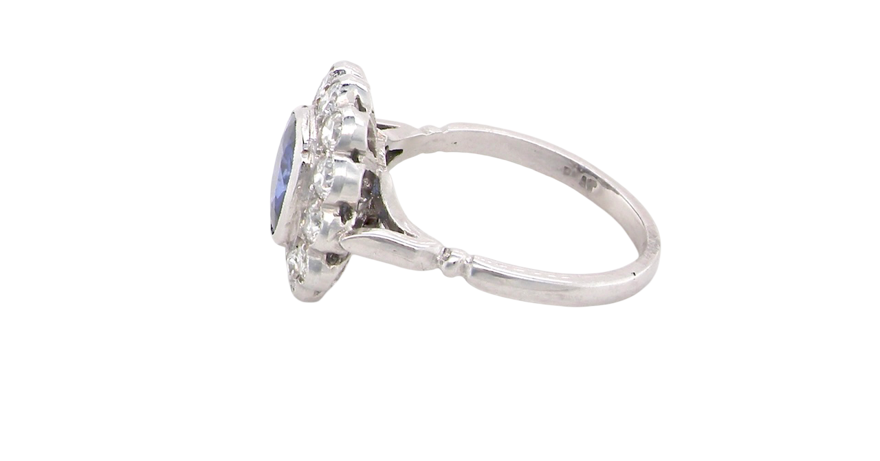 side An elegant and timeless cluster ring, centrally set with a beautiful mid to deep blue cushion-cut sapphire, measuring approximately 8 x 8mm (estimated 2.00 carats).