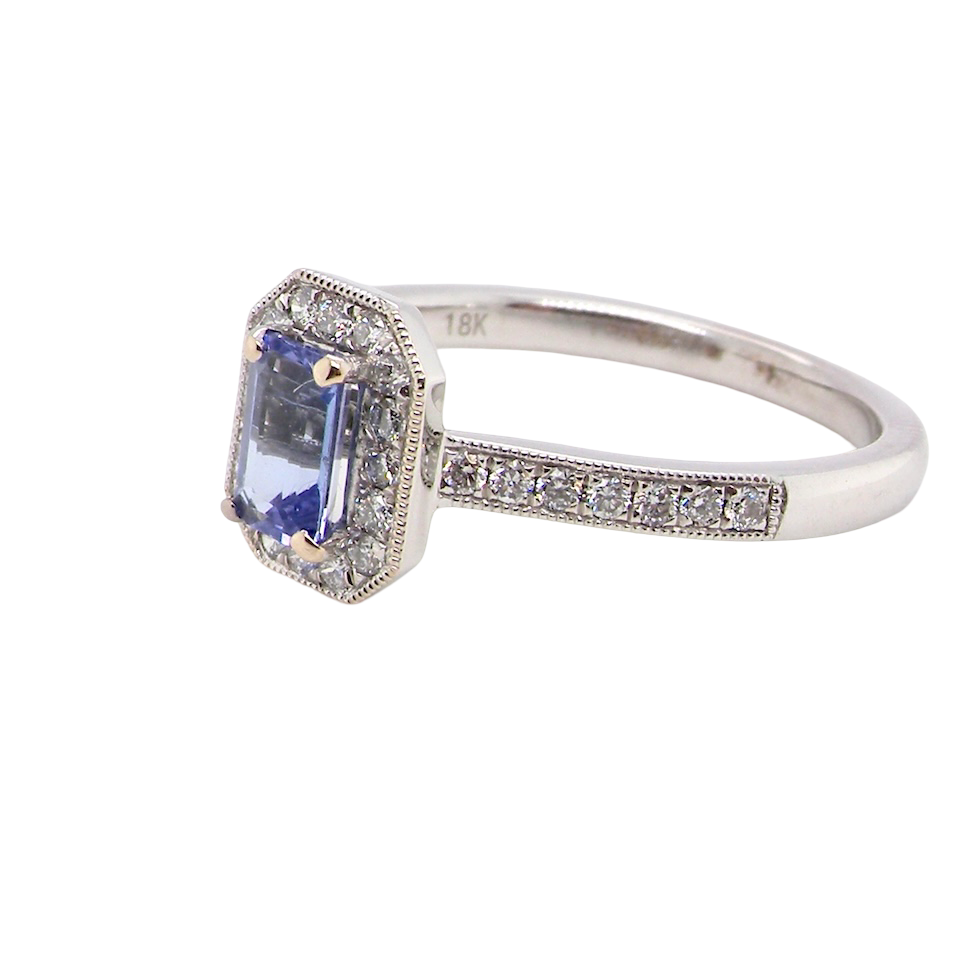 side An elegant cluster ring that features to the centre a rectangular tanzanite gemstone that measures 6x4mm (est 0.50 carats) AAA colour.