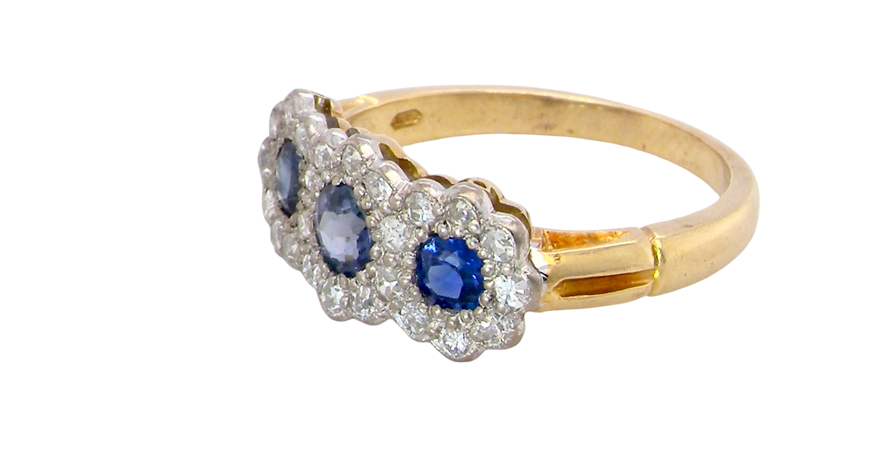 side An impressive multi cluster ring. Set with three cornflower blue sapphires to each centre, 4.3mm, and each side a 3.3mm sapphire. Based on an Edwardian design