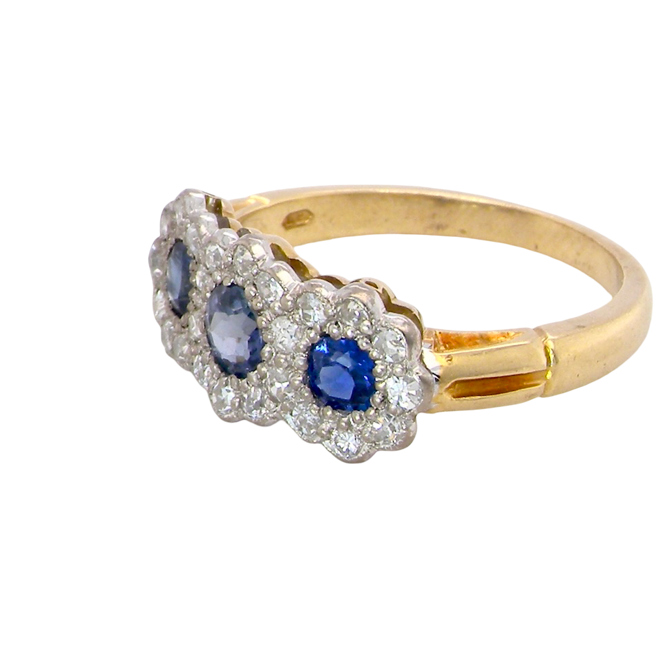side An impressive multi cluster ring. Set with three cornflower blue sapphires to each centre, 4.3mm, and each side a 3.3mm sapphire. Based on an Edwardian design