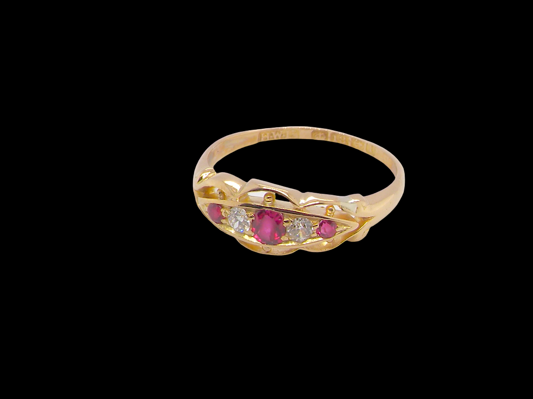 side Set with three bright rubies, centre 3x2.6mm, each end a 2mm ruby. Each side of the centre stone an old brilliant cut white diamond 2.8mm (est 0.08 carats) . Head measures 17x7mm, weight 3.4grams. 