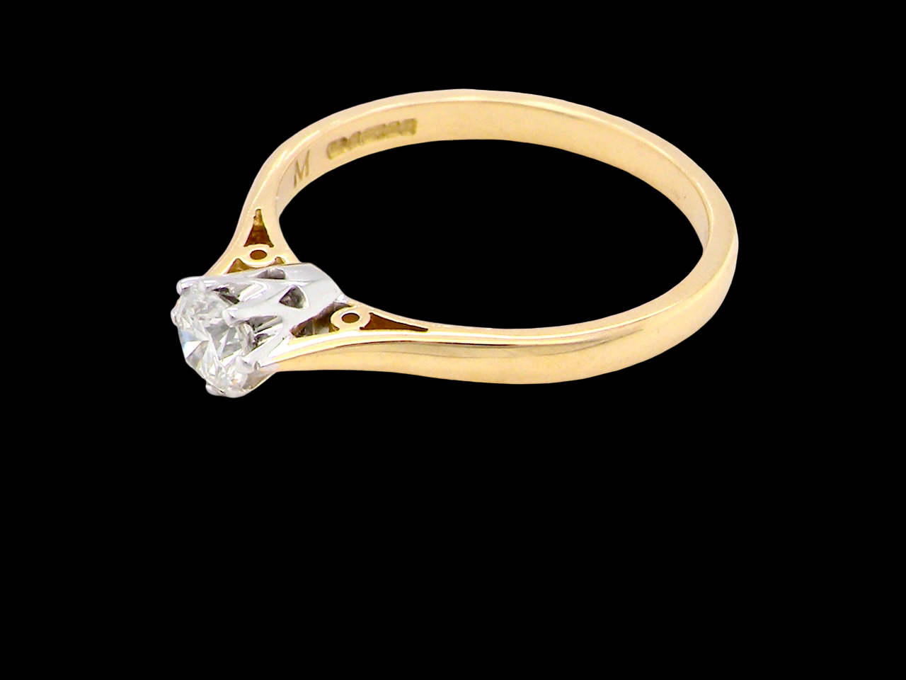 Gold ring with a diamond on a black background