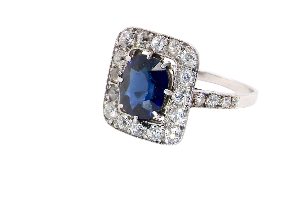 side beautiful original Art Deco cluster ring featuring a rich, dark blue oval-cut sapphire