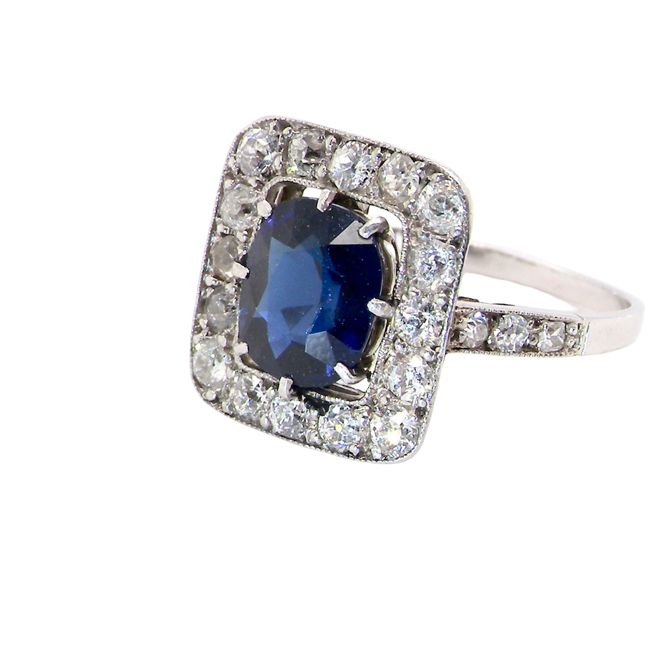 side beautiful original Art Deco cluster ring featuring a rich, dark blue oval-cut sapphire