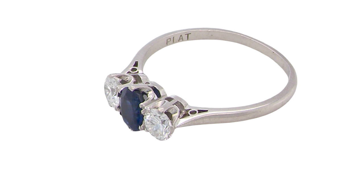 side classic trilogy ring set with an exquisite oval cut sapphire centre stone, hues of deep blue colour and measuring 6x4.2mm (est approx 0.50 carats)