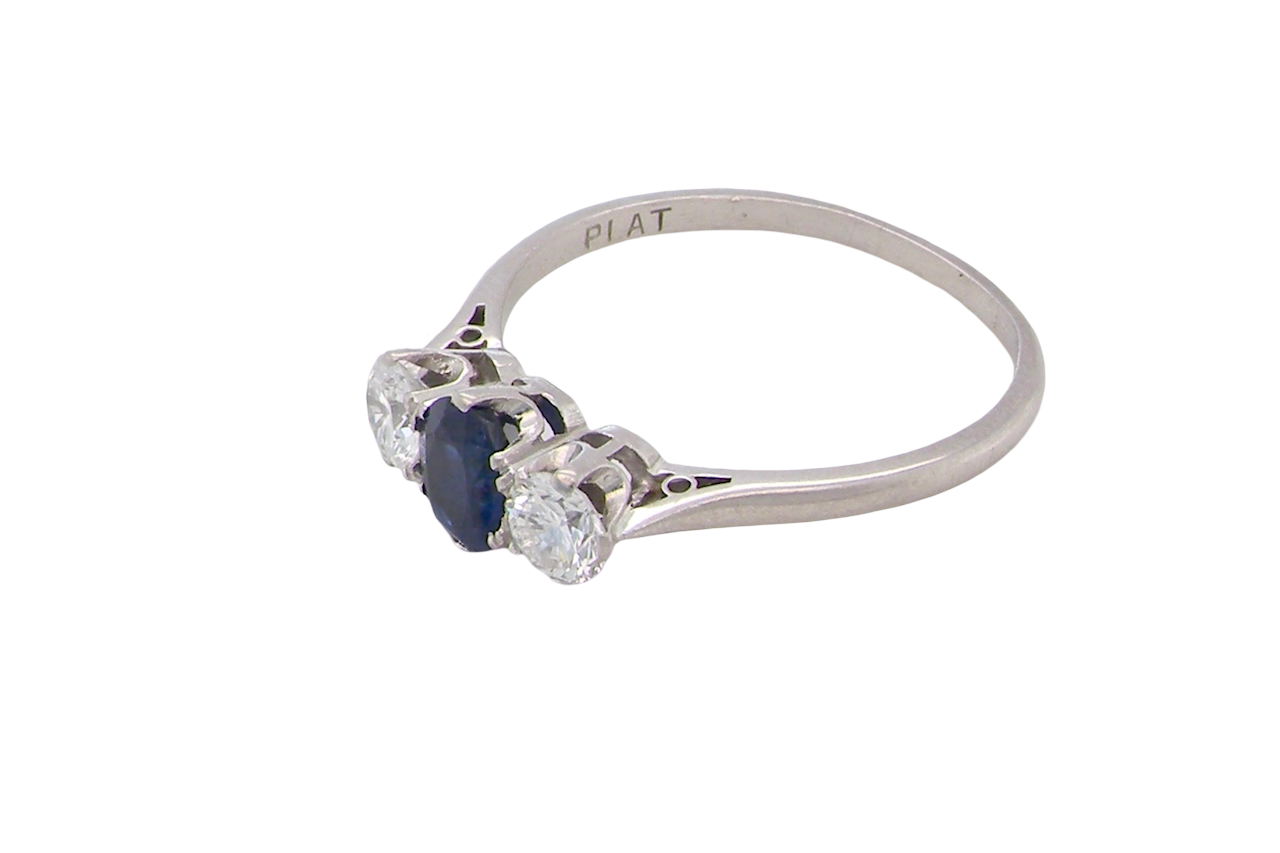 side classic trilogy ring set with an exquisite oval cut sapphire centre stone, hues of deep blue colour and measuring 6x4.2mm (est approx 0.50 carats)