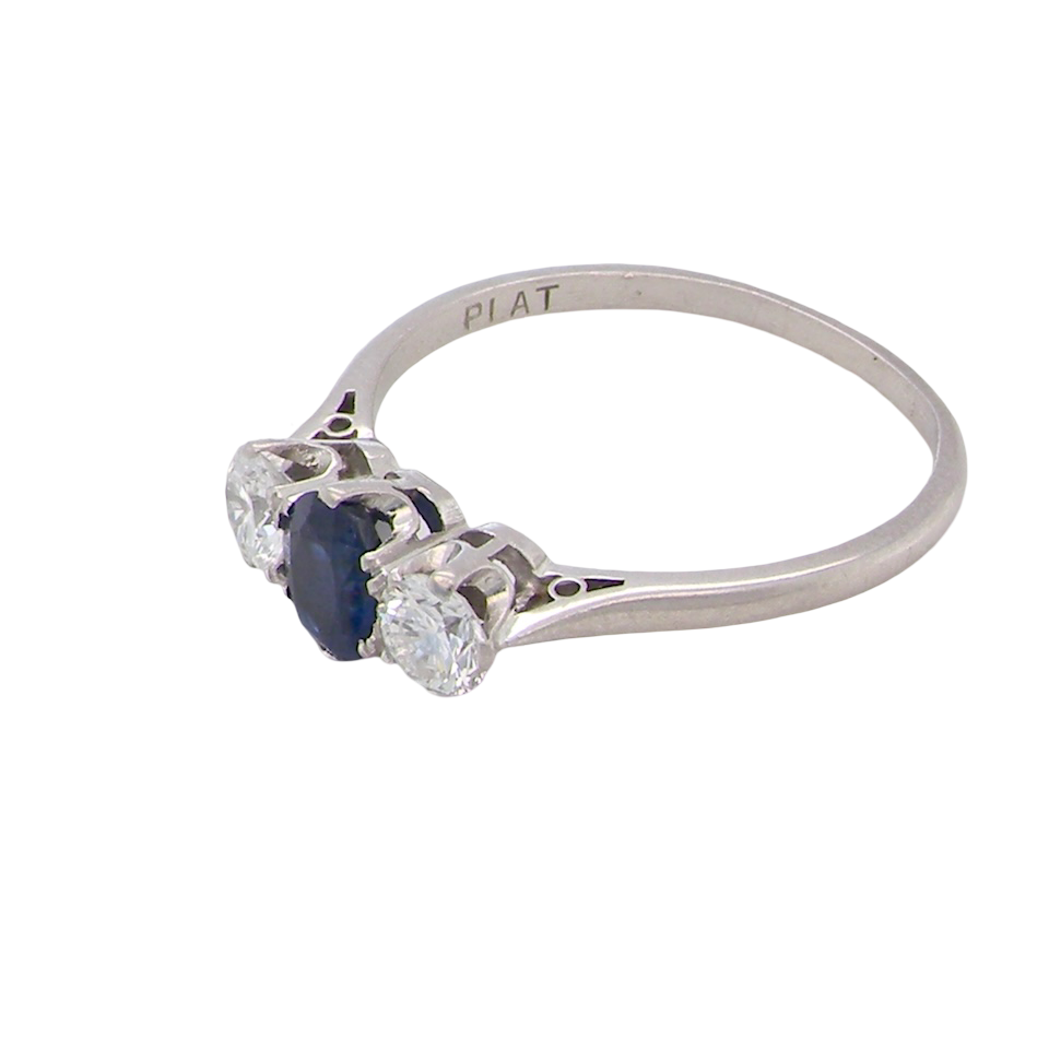 side classic trilogy ring set with an exquisite oval cut sapphire centre stone, hues of deep blue colour and measuring 6x4.2mm (est approx 0.50 carats)