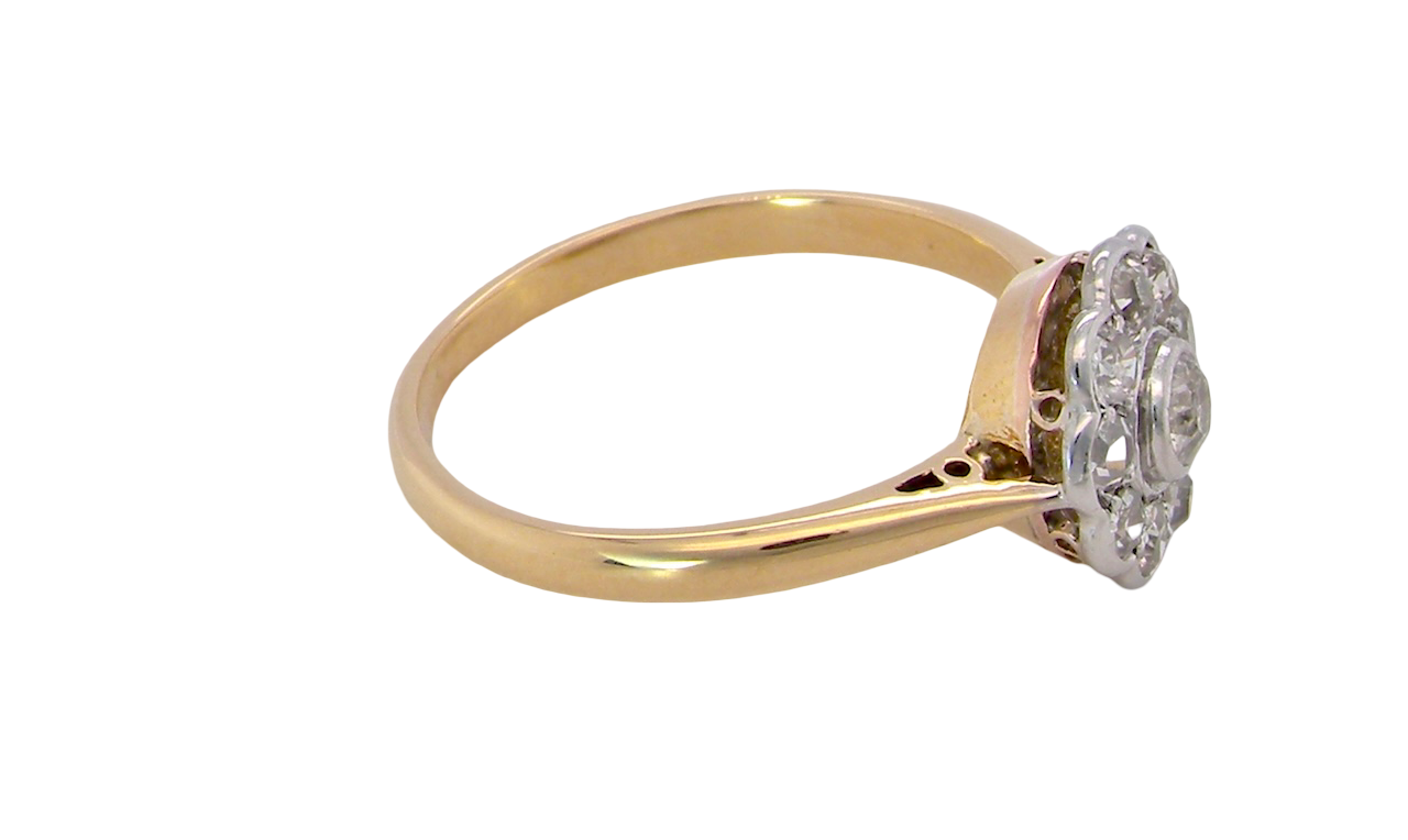 side early 20th-century vintage diamond cluster ring, featuring a classic daisy-shaped head set with nine old brilliant-cut white diamonds.