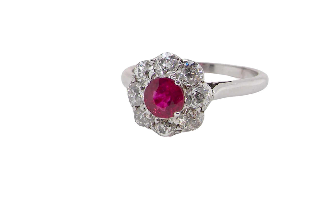 side view A beautiful cluster ring set with a raspberry-red ruby centre stone measuring 5mm in diameter, estimated at approximately 0.50 carats.