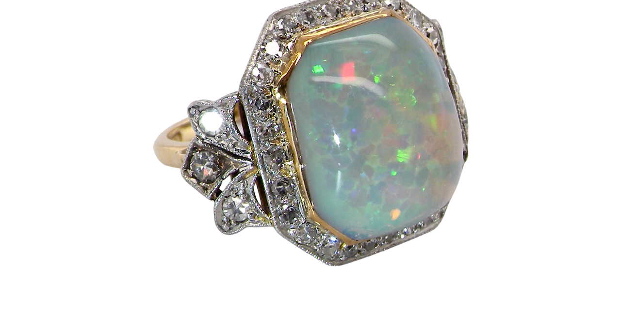 side view cabouchon cut opal shown is cushion shaped, measures 15x13 (5.78 carats) displaying a mass of vibrant colours, from flashes of fireglow orange, luminous greens, and lavender purples.
