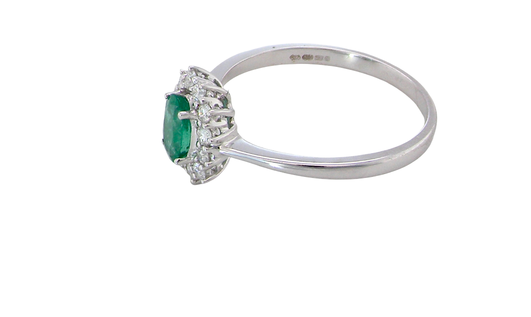 side A classic cluster ring set with an oval cut emerald centre stone, measures 6x4mm, grass green colour.
Complimented by an outer halo of twelve brilliant cut white diamonds, each 1.7mm (total est at 0.25 carats)
