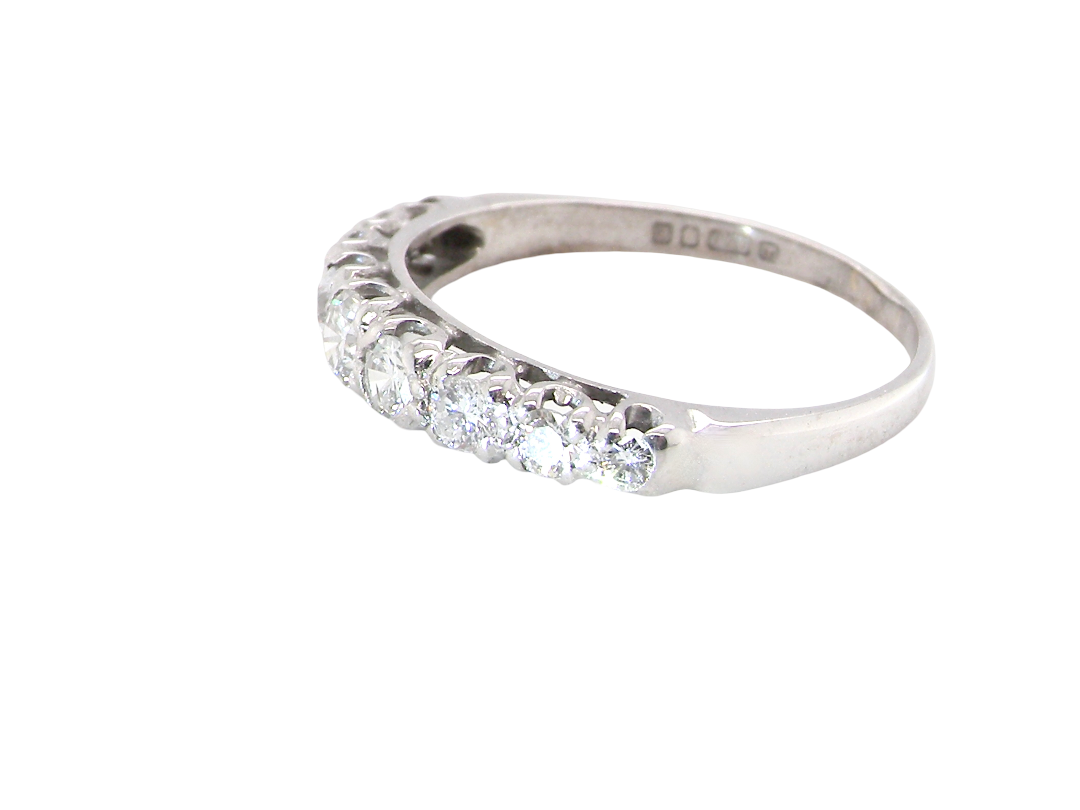 A ring with a row of round-cut diamonds set along the front half of a polished band, shown on a plain white background.