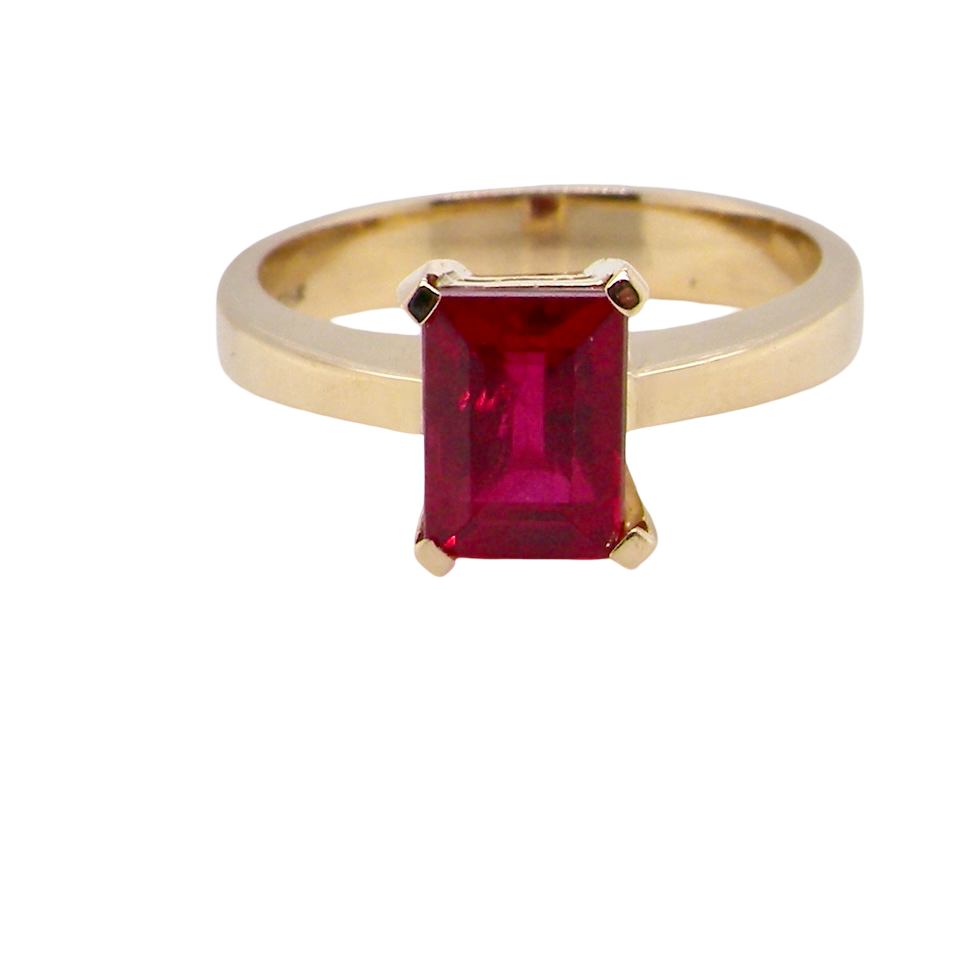 solitaire ring set with a rectangular cut red spinel stone. Measures 8x6mm.