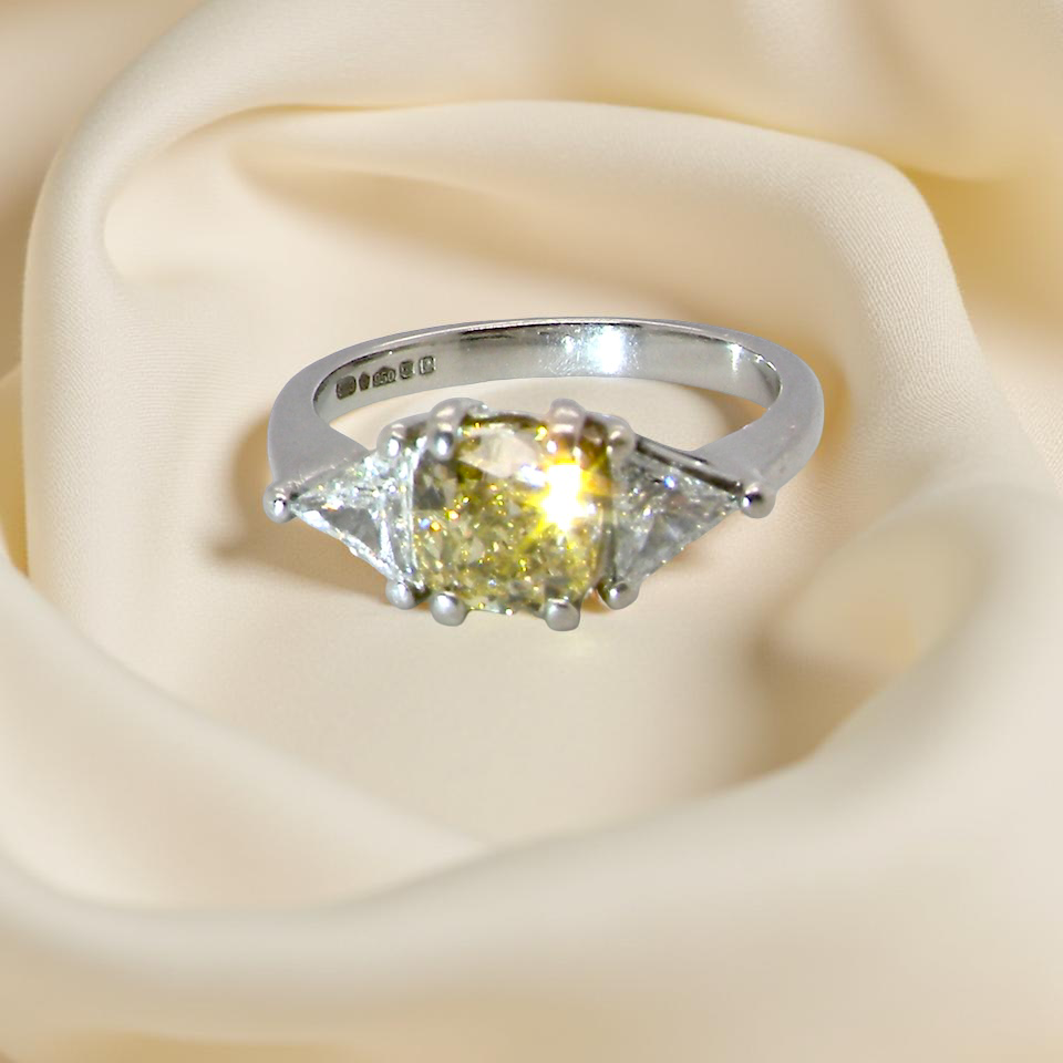 sparkle striking and elegant trilogy ring crafted in 18-carat white gold, set with a vibrant fancy yellow cushion-cut diamond