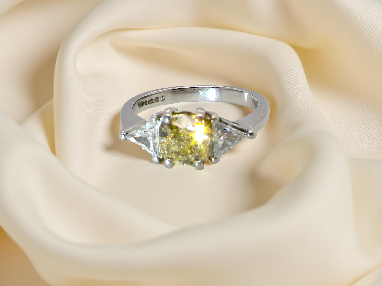 sparkle striking and elegant trilogy ring crafted in 18-carat white gold, set with a vibrant fancy yellow cushion-cut diamond