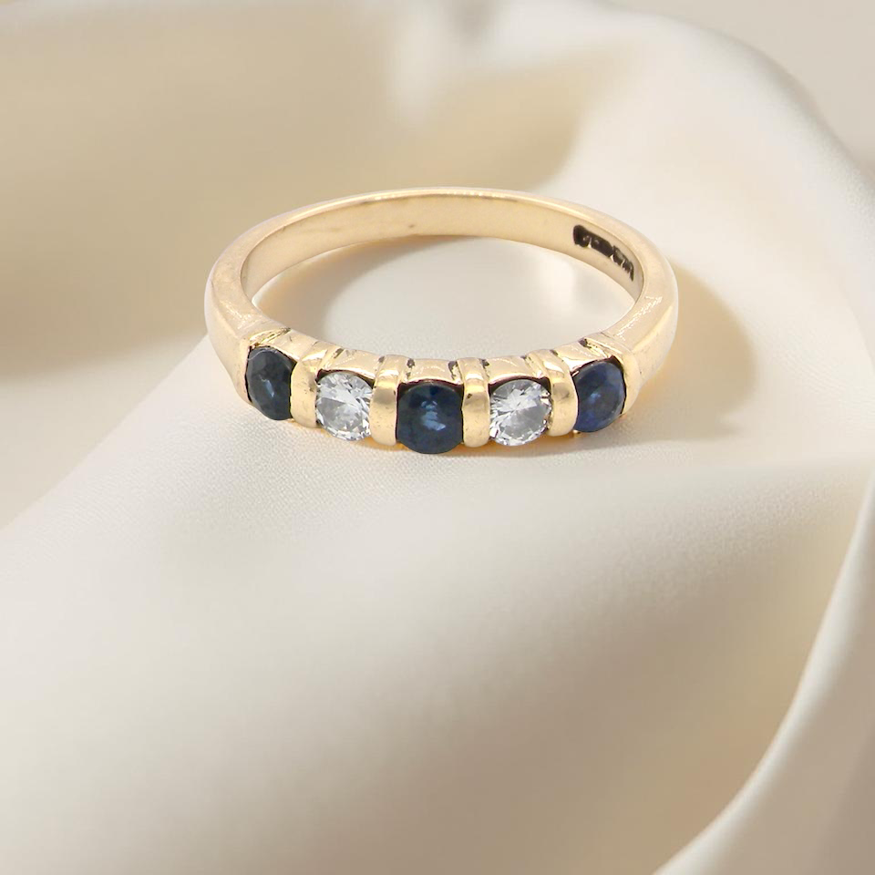 top 18-carat gold half-hoop eternity ring, set with three round mid-blue sapphires