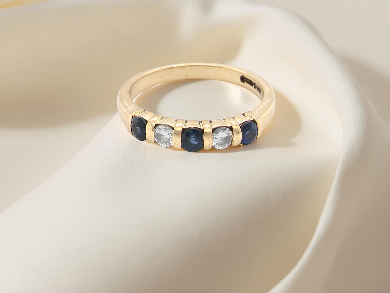top 18-carat gold half-hoop eternity ring, set with three round mid-blue sapphires