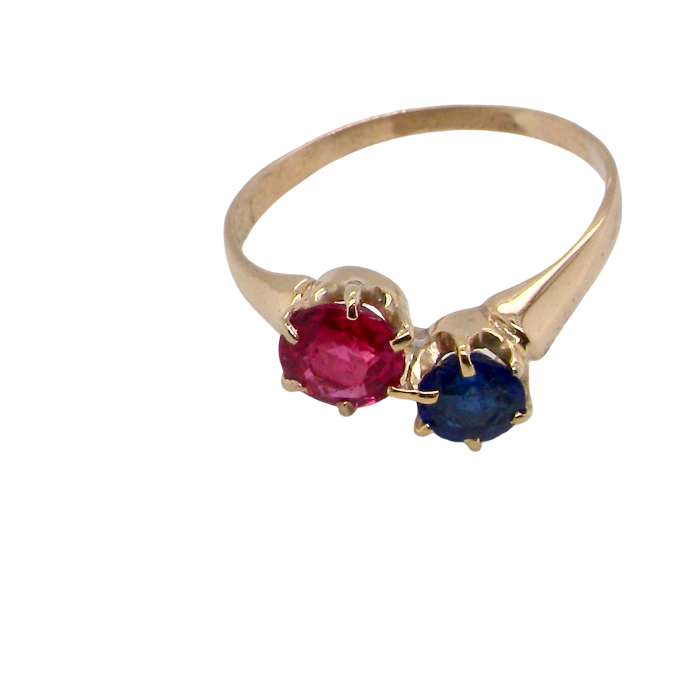 Gold ring with a red and blue gemstone on a white background