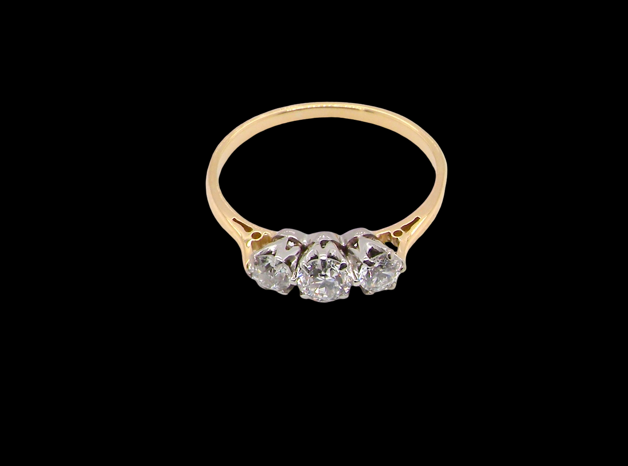 Gold ring with three diamonds on a black background