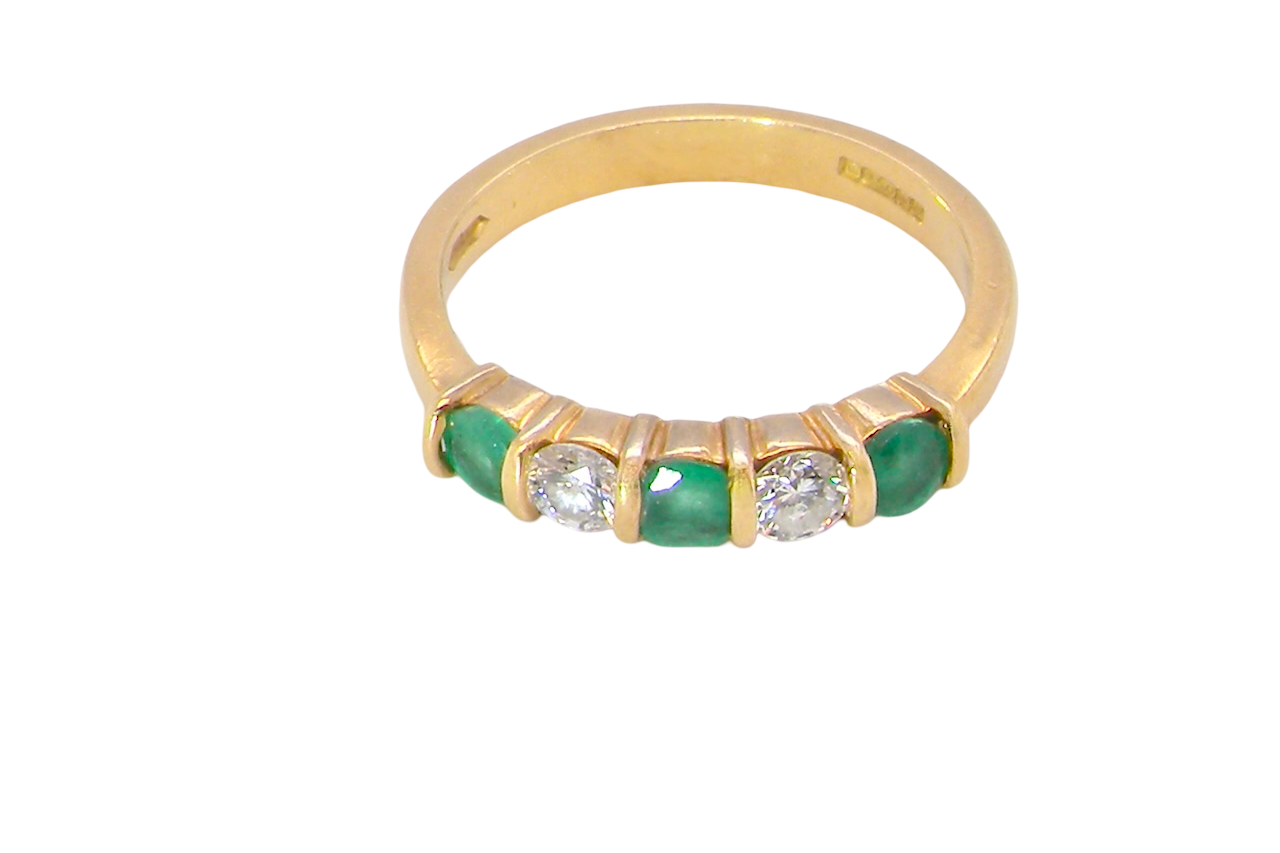 top A five stone ring set with three emeralds, each 3mm diameter.
Between each two brilliant cut white diamonds, each 3.4mm (0.15 carats each est), colour i-j, clarity Si.