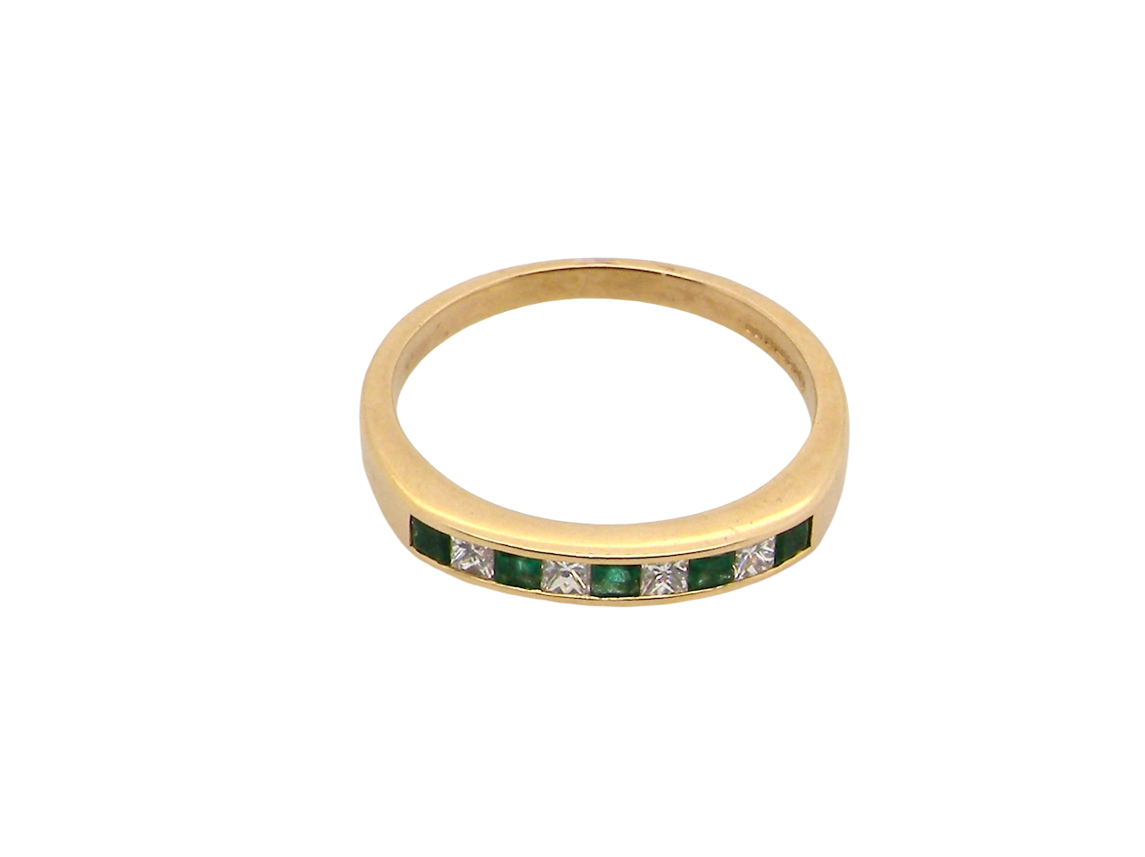 Gold ring with green gemstones and clear stones on a white background