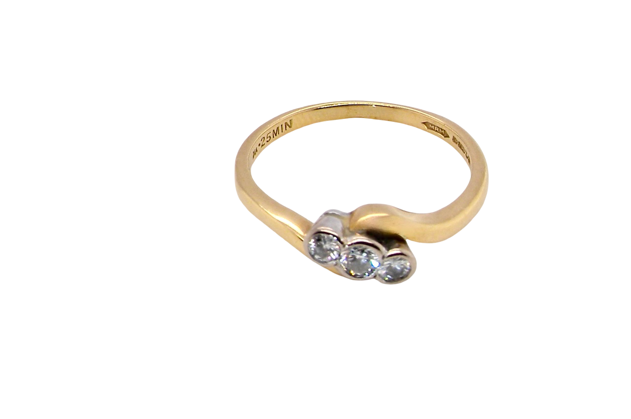 top An 18 carat yellow gold three stone ring, cross over style, and set with brilliant cut white diamonds.
Centre stone 3mm (0.10 carats)