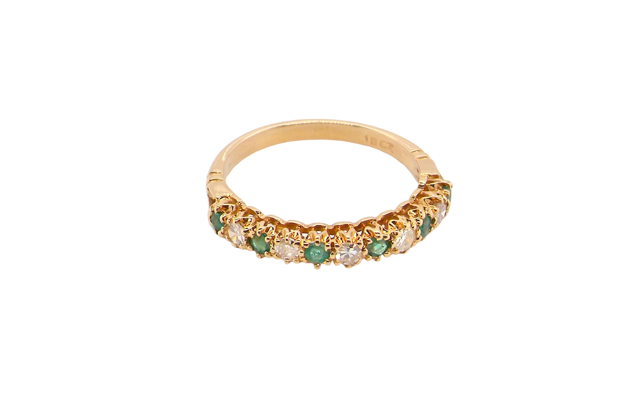 top half-eternity ring set with alternating emeralds and diamonds.