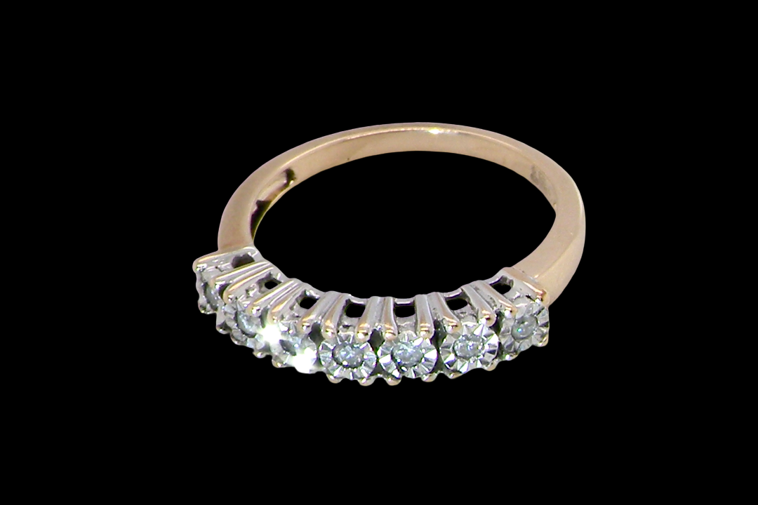 top view 9 carat gold half hoop eternity ring.
Set with seven small white diamonds, each 1.8mm within an illusion setting that is 3.8mm in diameter, and white gold. 