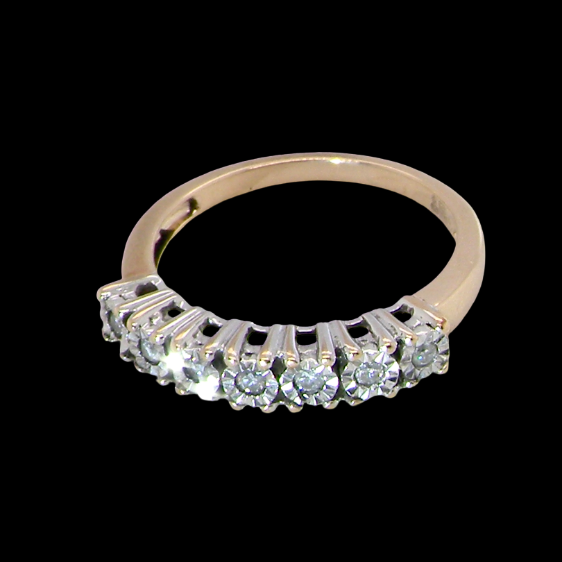 top view 9 carat gold half hoop eternity ring.
Set with seven small white diamonds, each 1.8mm within an illusion setting that is 3.8mm in diameter, and white gold. 