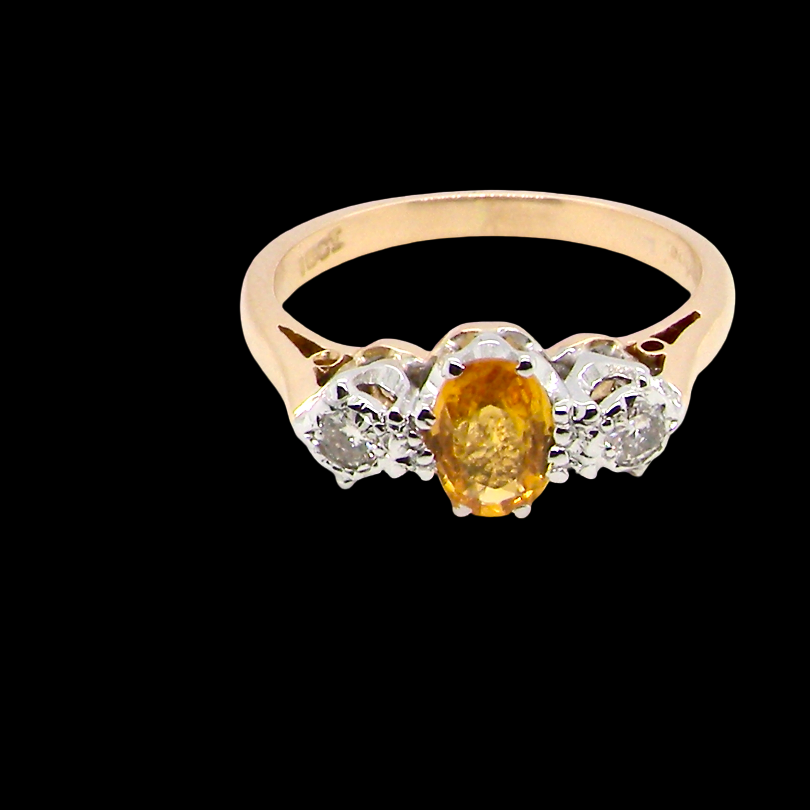 top view A beautiful 18 carat yellow gold trilogy ring, combining the warm golden tones of a yellow sapphire with white diamonds.