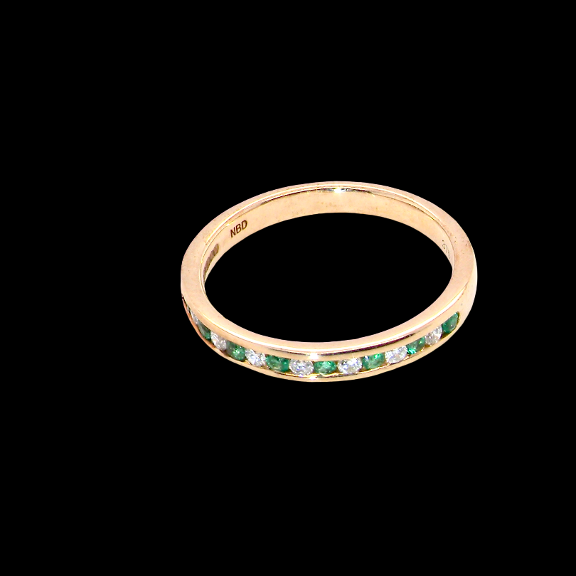 top view A brand new half hoop eternity ring. Set with eight 1.3mm emeralds (total 0.12 carats) and interspaced with brilliant cut white diamonds, each 1.3mm (0.10 carats)