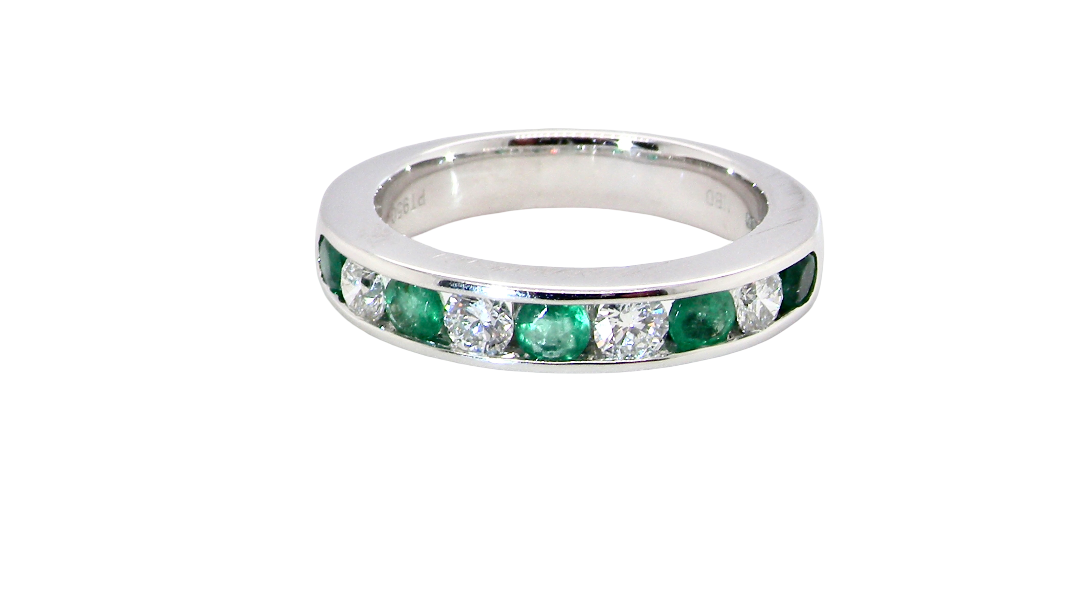 top view A fine platinum half hoop eternity ring. This is a new ring*. Channel set gem stones, five bright green emeralds 2.6mm each (0.54 carats total)