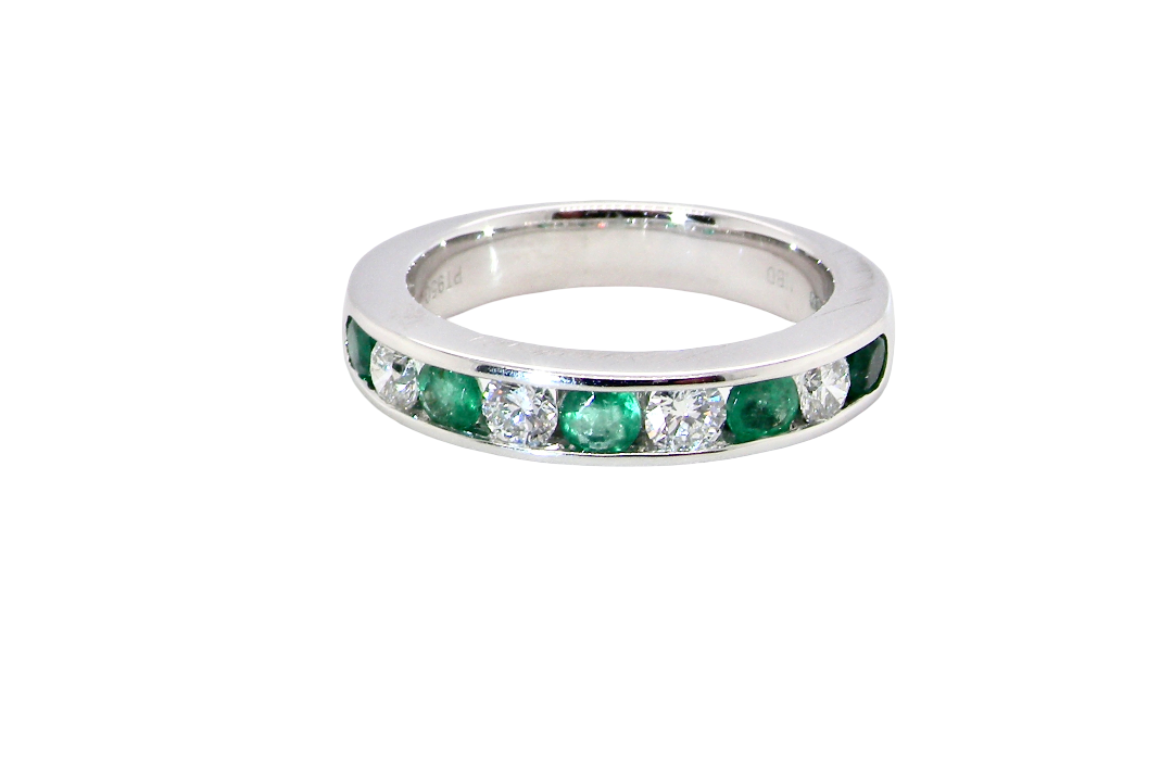 top view A fine platinum half hoop eternity ring. This is a new ring*. Channel set gem stones, five bright green emeralds 2.6mm each (0.54 carats total)