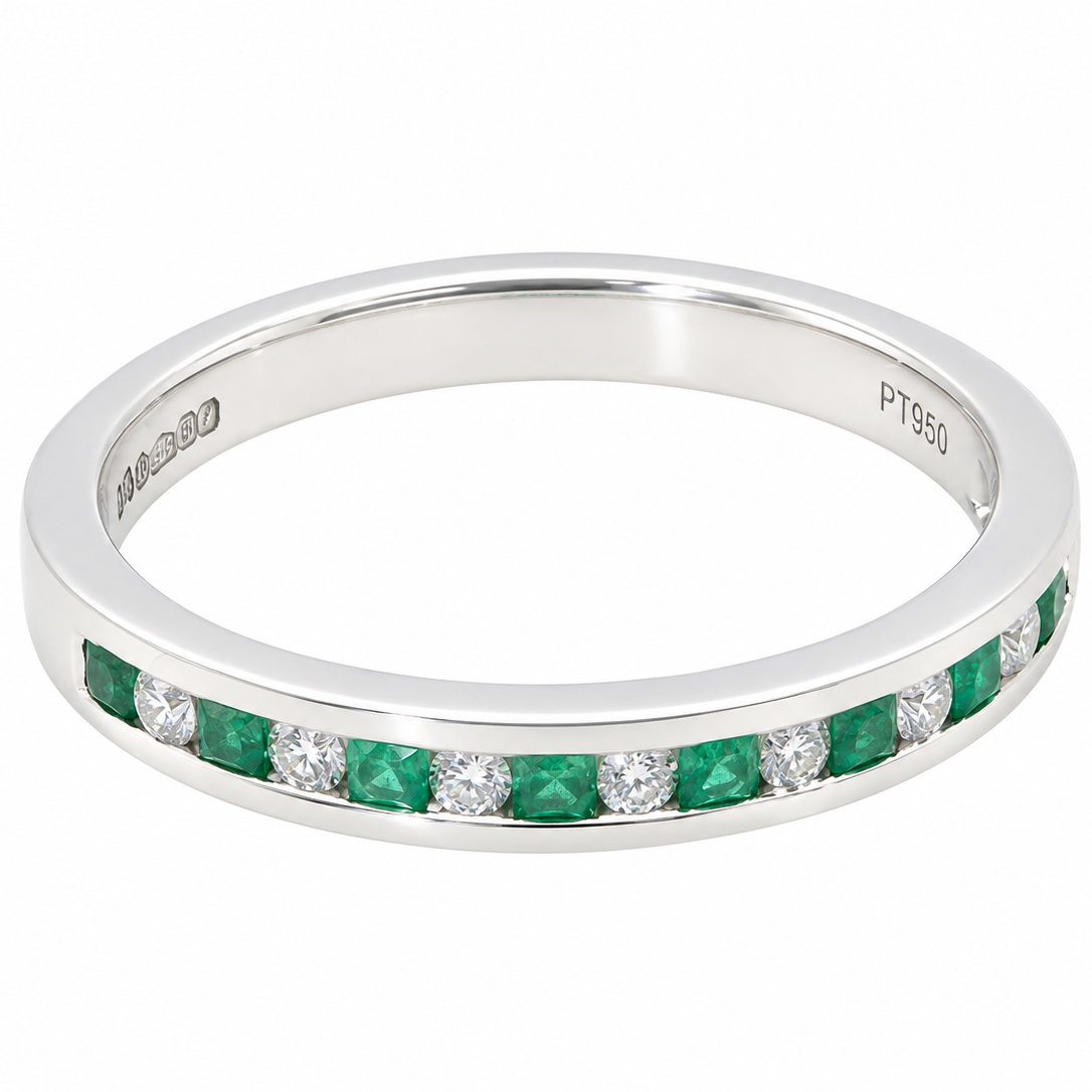 an eternity ring featuring a channel setting of round-cut green emeralds and clear diamonds. The inner band is engraved with 'M390' and 'PT950'.
