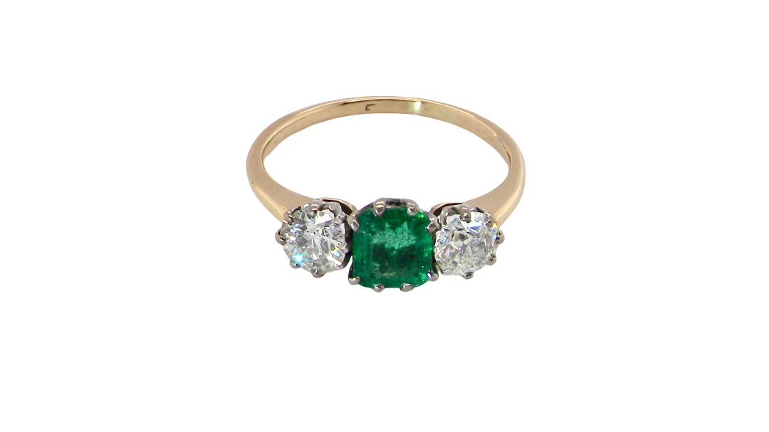 top view A vintage trilogy ring. Centre stone a step cut emerald, 6.5x5.5mm (est .75 carats). The emerald is dark green.