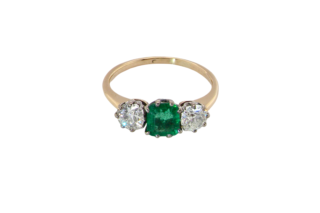top view A vintage trilogy ring. Centre stone a step cut emerald, 6.5x5.5mm (est .75 carats). The emerald is dark green.