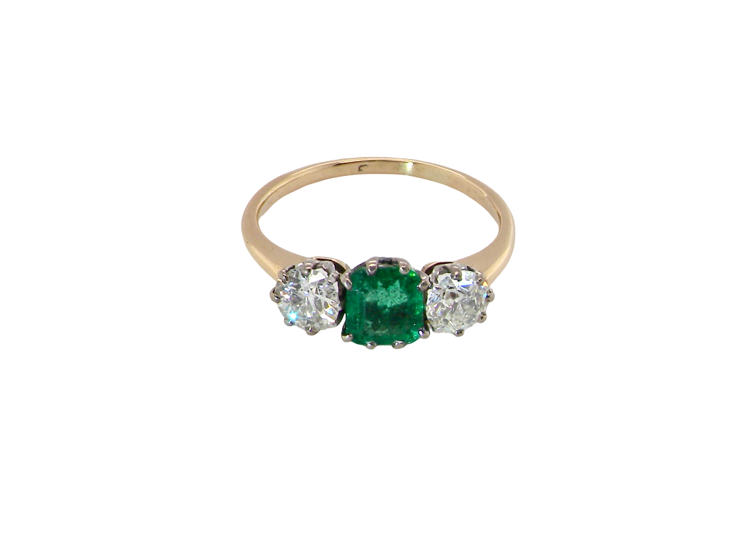 top view A vintage trilogy ring. Centre stone a step cut emerald, 6.5x5.5mm (est .75 carats). The emerald is dark green.