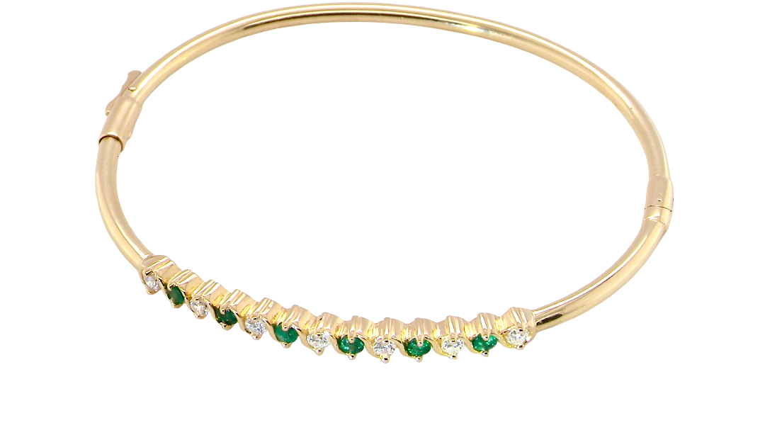 top view A yellow gold bangle. Features alternate emeralds and diamonds. Six 2.7mm emeralds and seven brilliant cut white diamonds, each 2.7mm (total diamond total 0.50 carats)