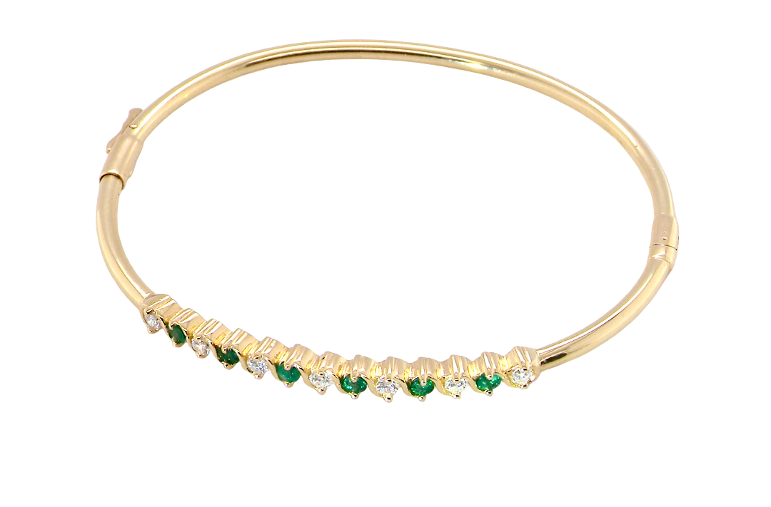 top view A yellow gold bangle. Features alternate emeralds and diamonds. Six 2.7mm emeralds and seven brilliant cut white diamonds, each 2.7mm (total diamond total 0.50 carats)