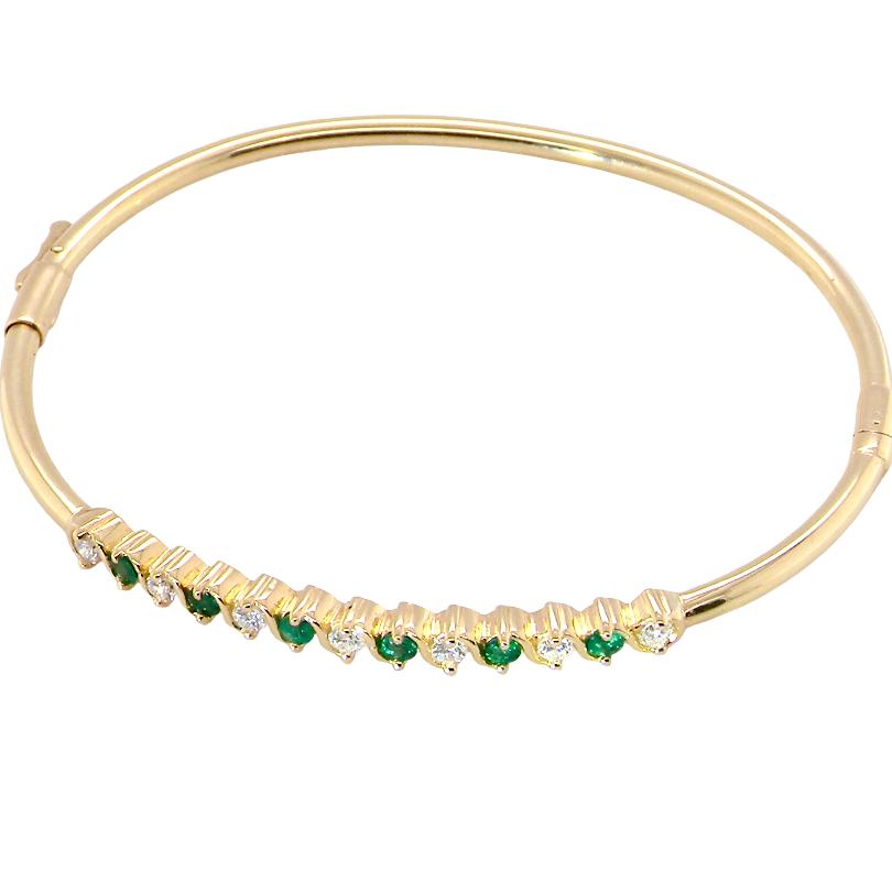 top view A yellow gold bangle. Features alternate emeralds and diamonds. Six 2.7mm emeralds and seven brilliant cut white diamonds, each 2.7mm (total diamond total 0.50 carats)