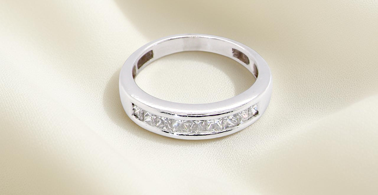 top view An elegant half-hoop eternity ring set with nine princess-cut white diamonds, each measuring approximately 2.5mm, with a total estimated diamond weight of 0.90 carats.