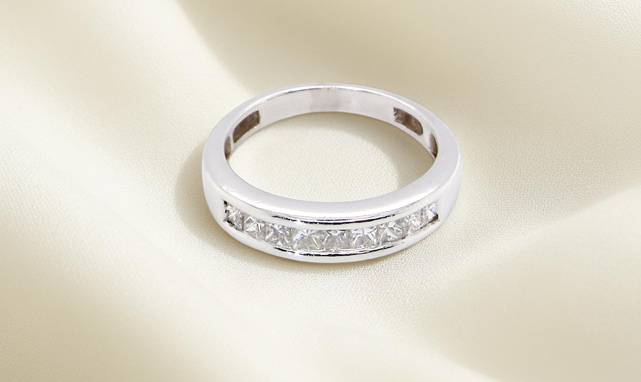 top view An elegant half-hoop eternity ring set with nine princess-cut white diamonds, each measuring approximately 2.5mm, with a total estimated diamond weight of 0.90 carats.