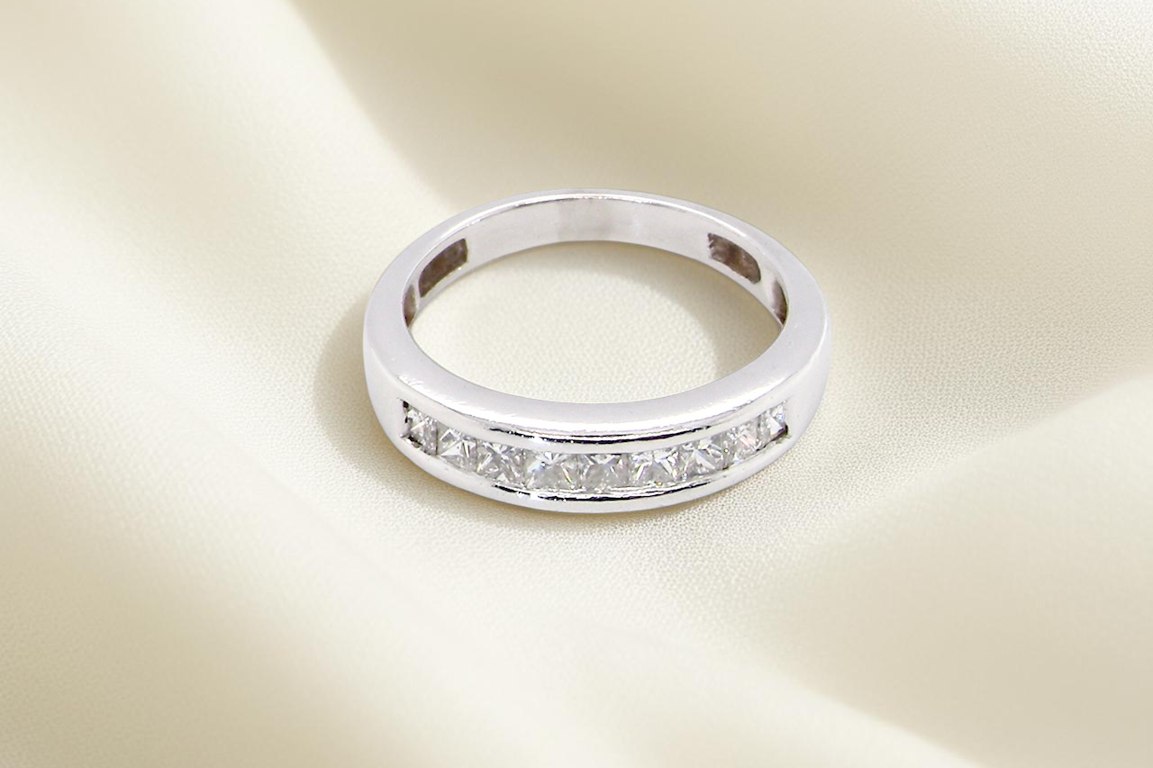 top view An elegant half-hoop eternity ring set with nine princess-cut white diamonds, each measuring approximately 2.5mm, with a total estimated diamond weight of 0.90 carats.